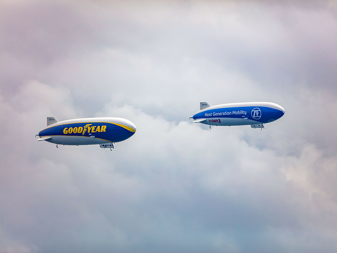 Beide Zeppelin fliegen am bewölkten Himmel