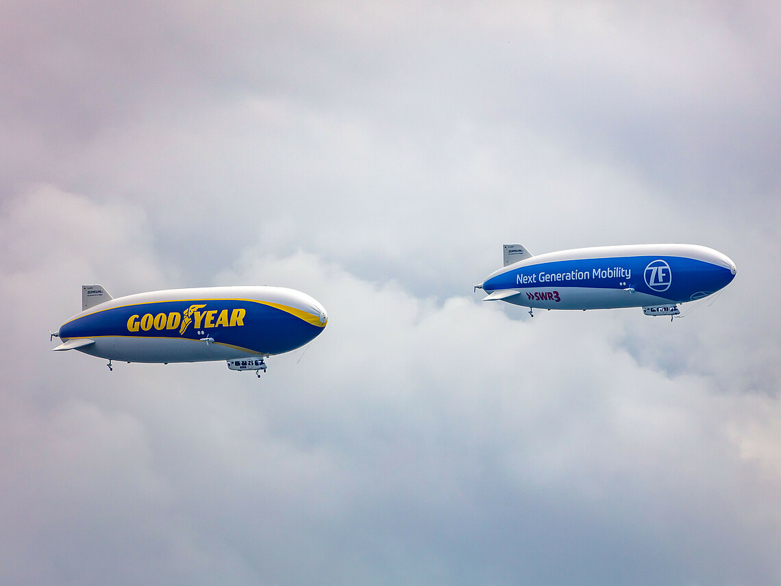 Beide Zeppelin fliegen am bewölkten Himmel