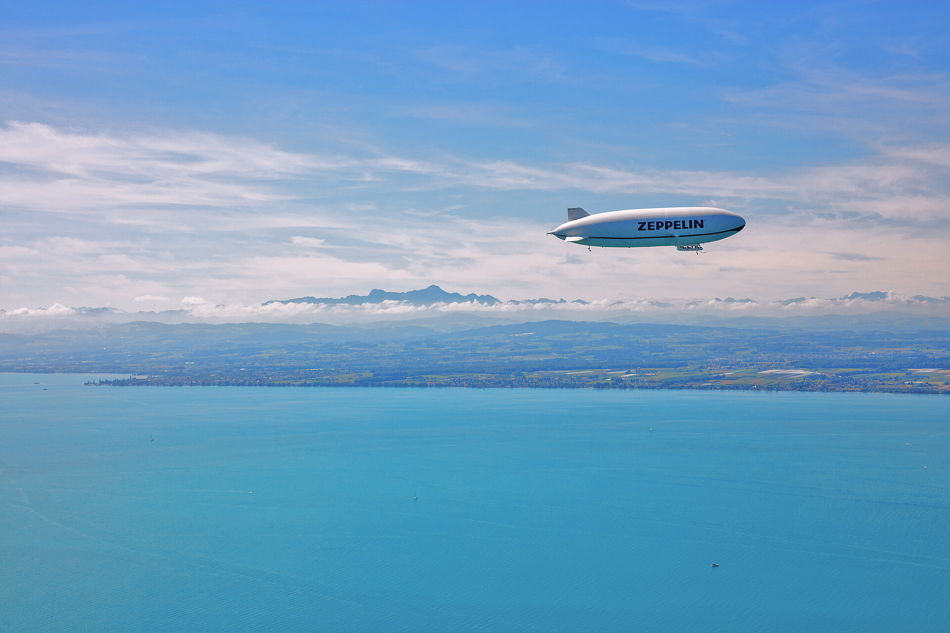 Zeppelin über dem Bodensee im Hintergrund Berg Säntis